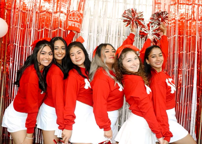 Group of women in red and white cheerleading outfits.